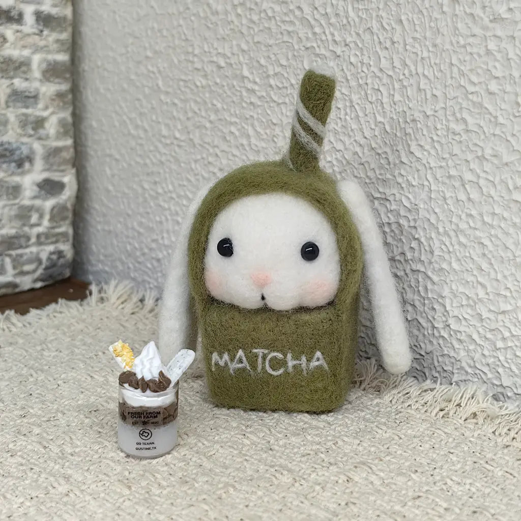 Matcha Bunny felt figurine beside a miniature parfait in a cozy cafe scene