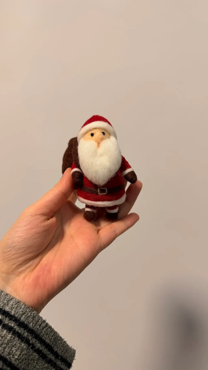 Handmade Walking Santa felt figurine shown in hand for size reference