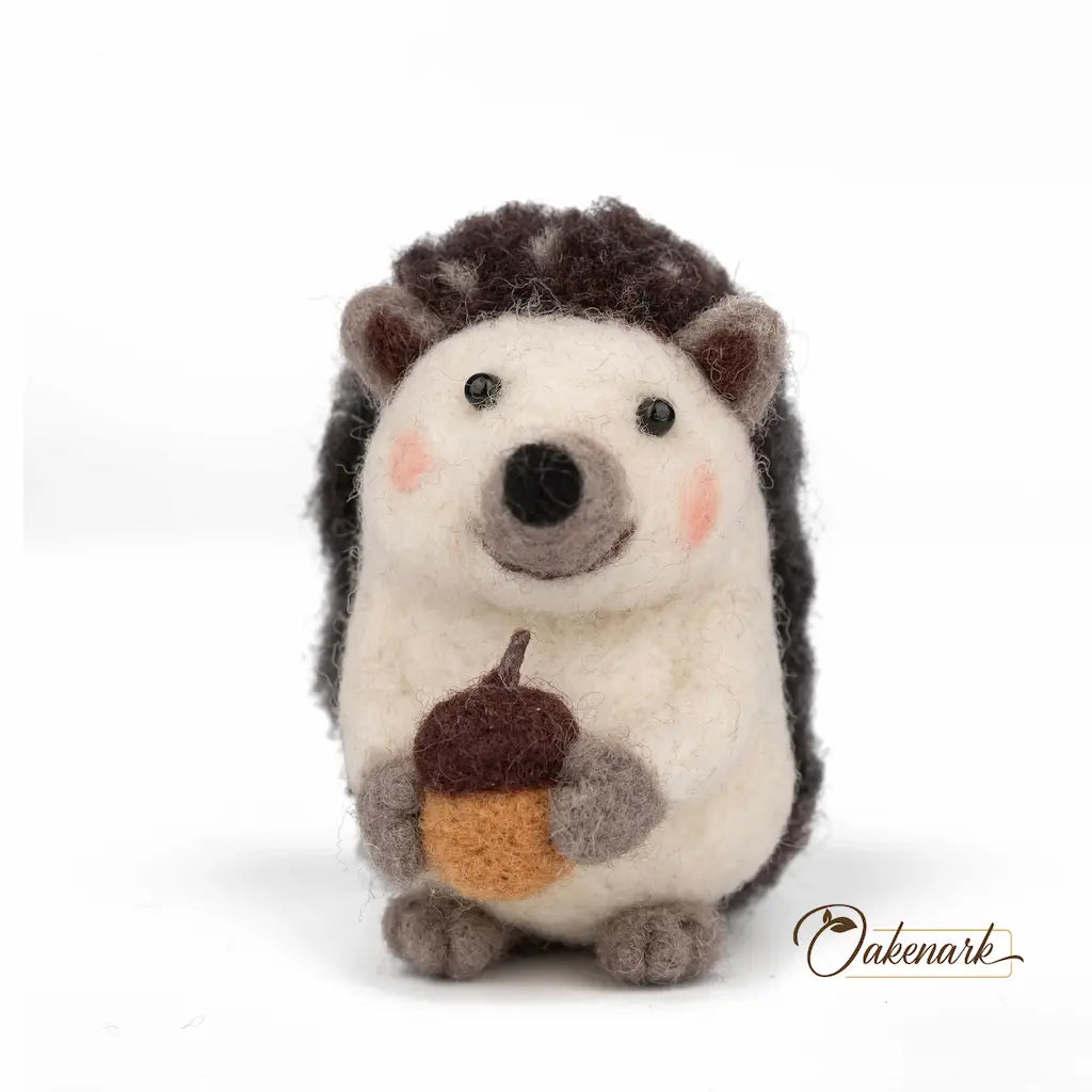 Stuffed hedgehog toy holding an acorn on a white background