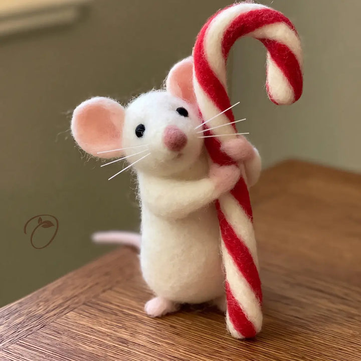Ivory wool felt mouse hugging an oversized red and cream striped candy cane, with pink ears and paws.