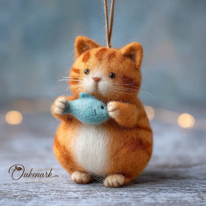 Felted cat ornament holding a fish, with &