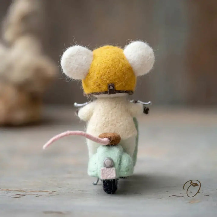 Toy mouse on a scooter with a yellow helmet on a wooden surface