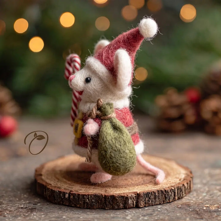 Side view of a felt Santa mouse showing its pink ear, red hat, tied green gift sack and curling tail