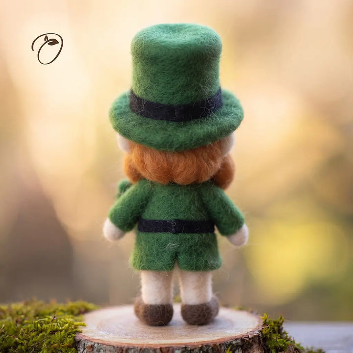 Back view of a wool felt leprechaun with a green top hat, orange hair, a dark waist belt and split green coat tails.