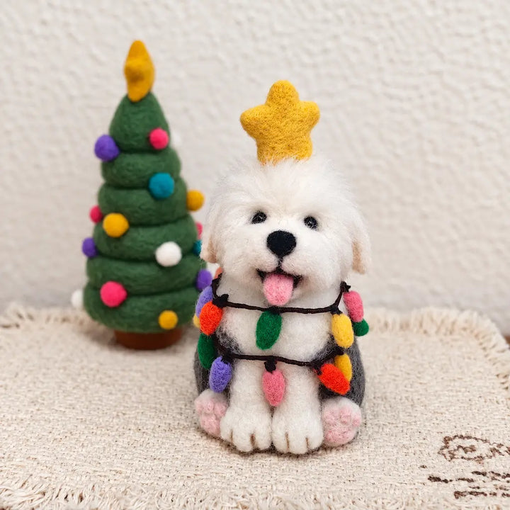 Front view of an Old English Sheepdog felt figurine wearing a golden star and bulb garlands beside a decorated felt Christmas tree.