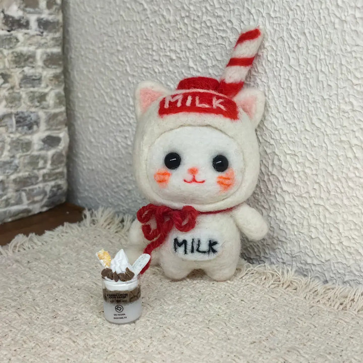 Milk Carton Cat felt figurine beside a miniature parfait in a cozy cafe scene
