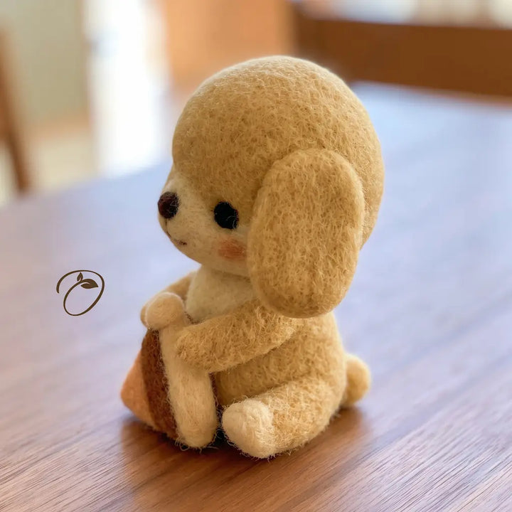Side view of Sweet Treat Puppy felt figurine holding a small triangular pie slice