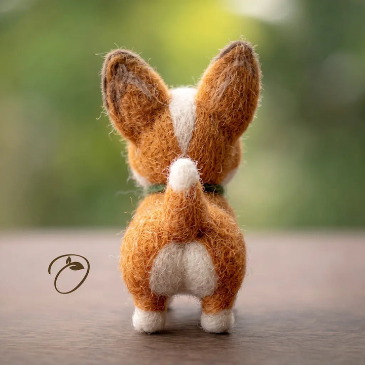 Back view of corgi wool felt figurine with upright ears and white-tipped tail