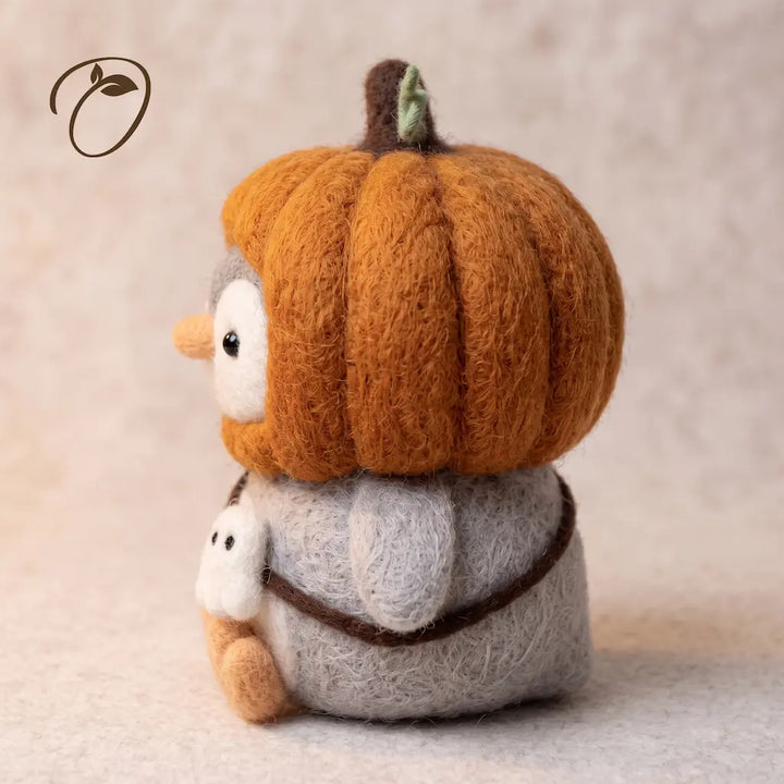 Side view of Pumpkin Rascal Penguin felt figurine with segmented pumpkin hood and ghost charm