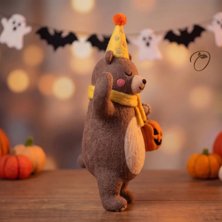 Side view of Pumpkin Party Bear felt figurine with yellow scarf and party hat