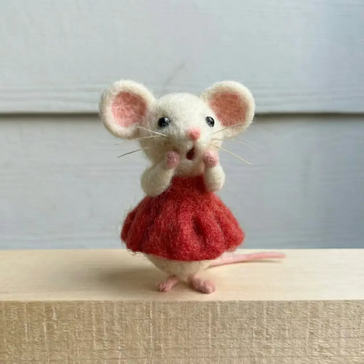 Toy mouse in a red dress on a neutral background