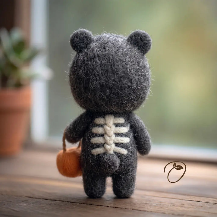 Back view of a charcoal felt costume with rounded hood ears, cream skeleton details and a small round tail