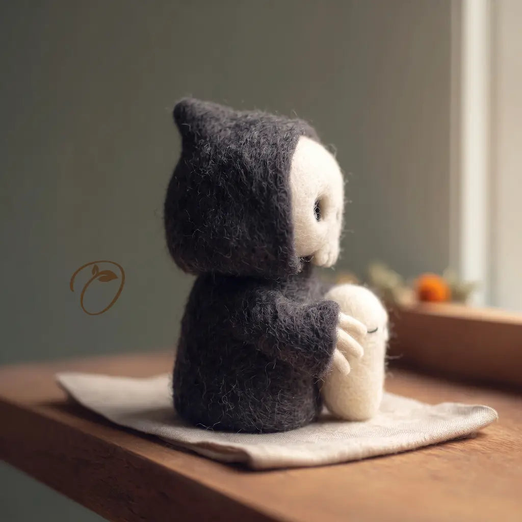 Side view of a hooded wool felt reaper, showing its ivory skull profile and pale skeletal hands around a sleepy ghost.