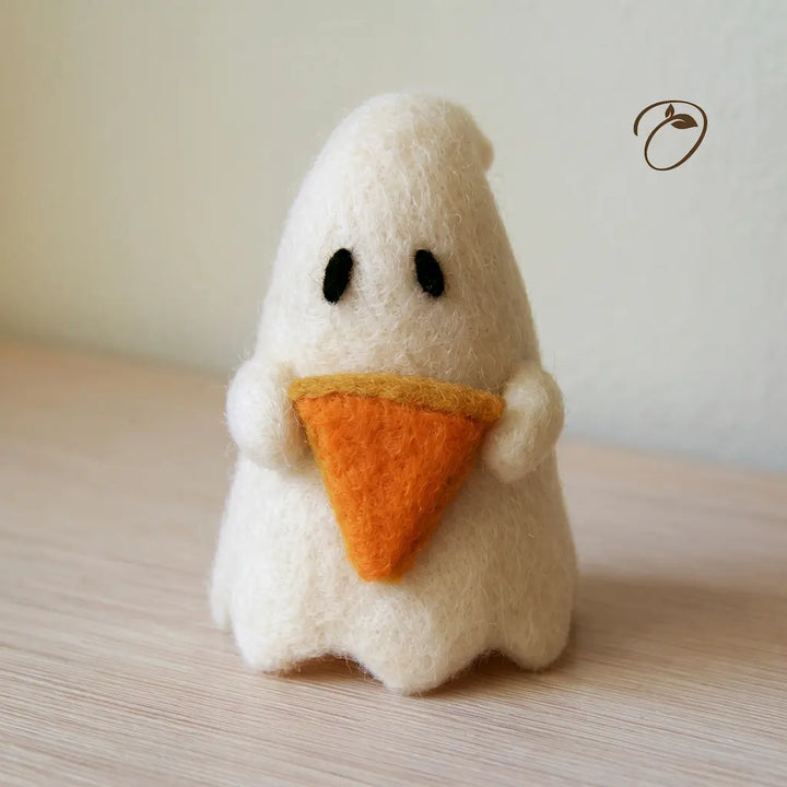 Front view of an ivory wool felt ghost holding an orange pumpkin pie slice with golden crust, with dark oval eyes and a scalloped hem.