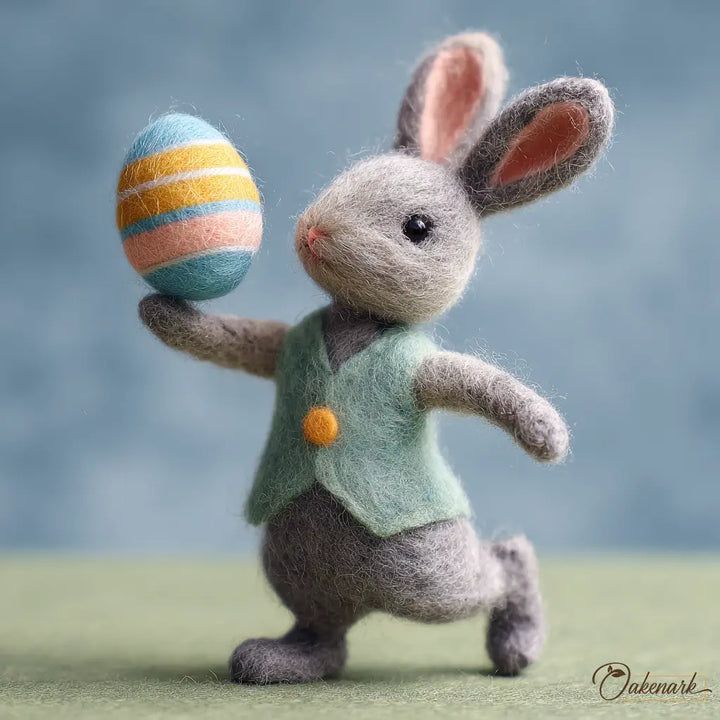 Felted bunny toy holding a colorful Easter egg against a blurred background
