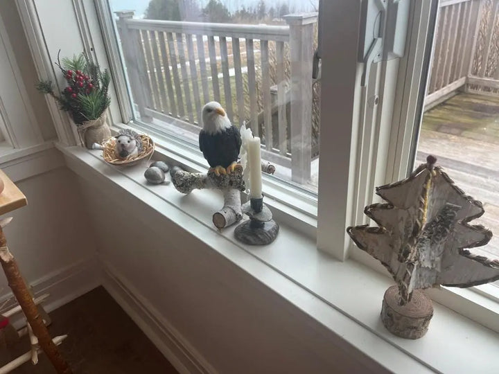 Decorative items on a windowsill including a bird sculpture, candle, and star-shaped object.