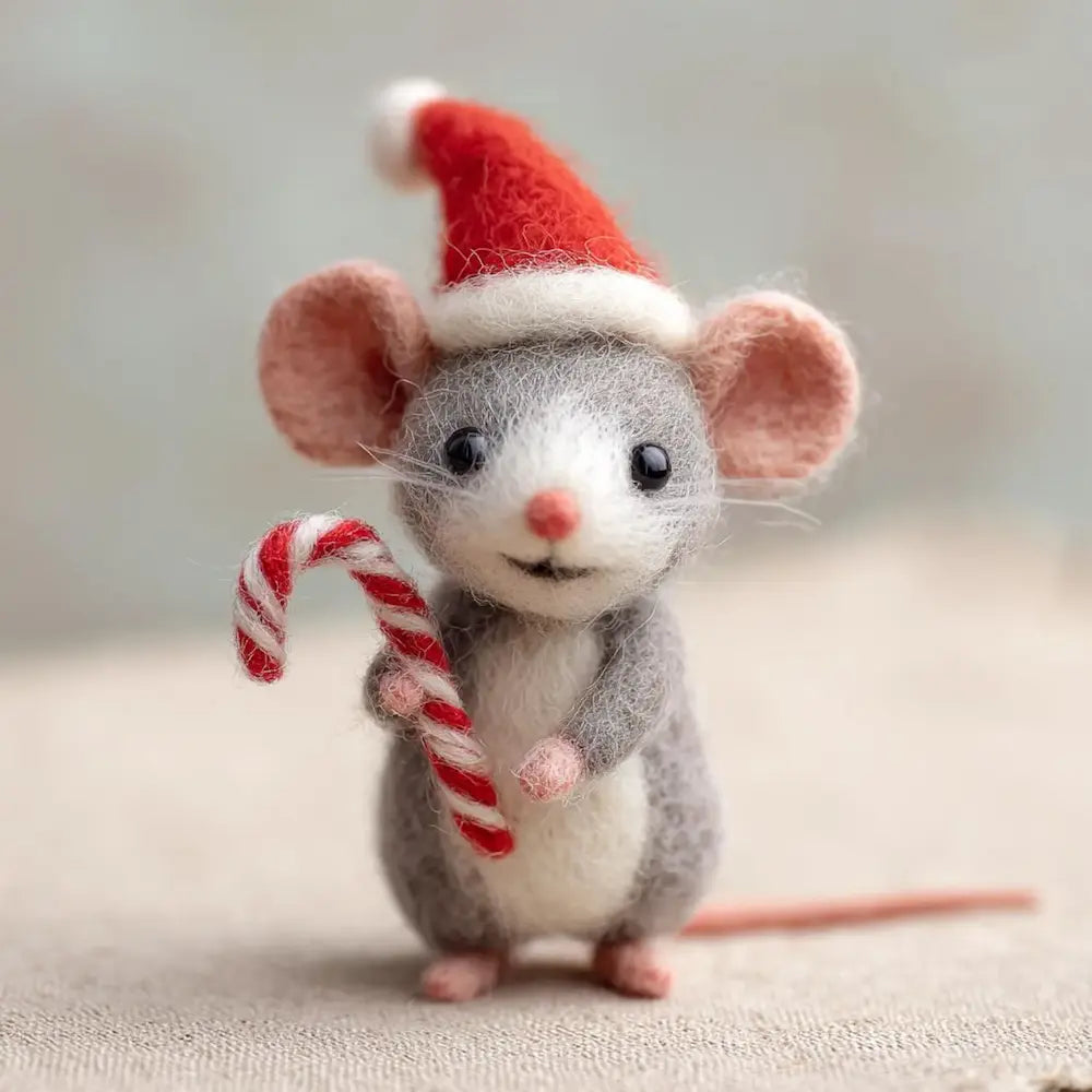 Felted mouse toy wearing a Santa hat and holding a candy cane on a neutral background