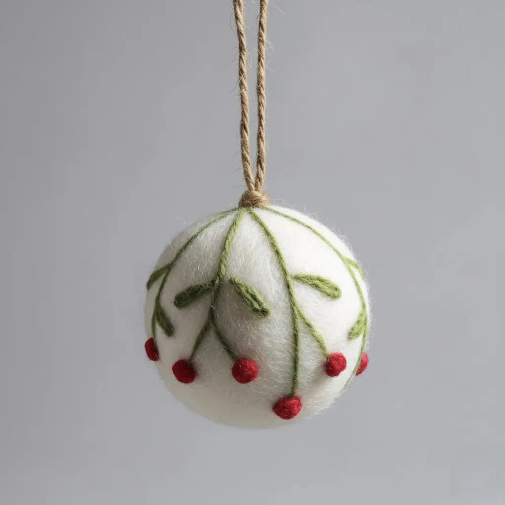 Felted Christmas ornament with green leaves and red berries on a gray background