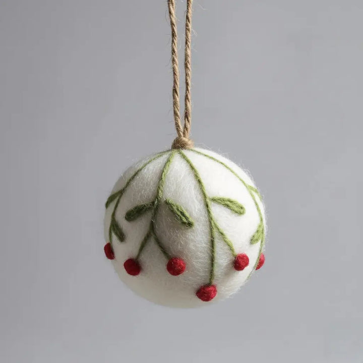 Felted Christmas ornament with green leaves and red berries on a gray background