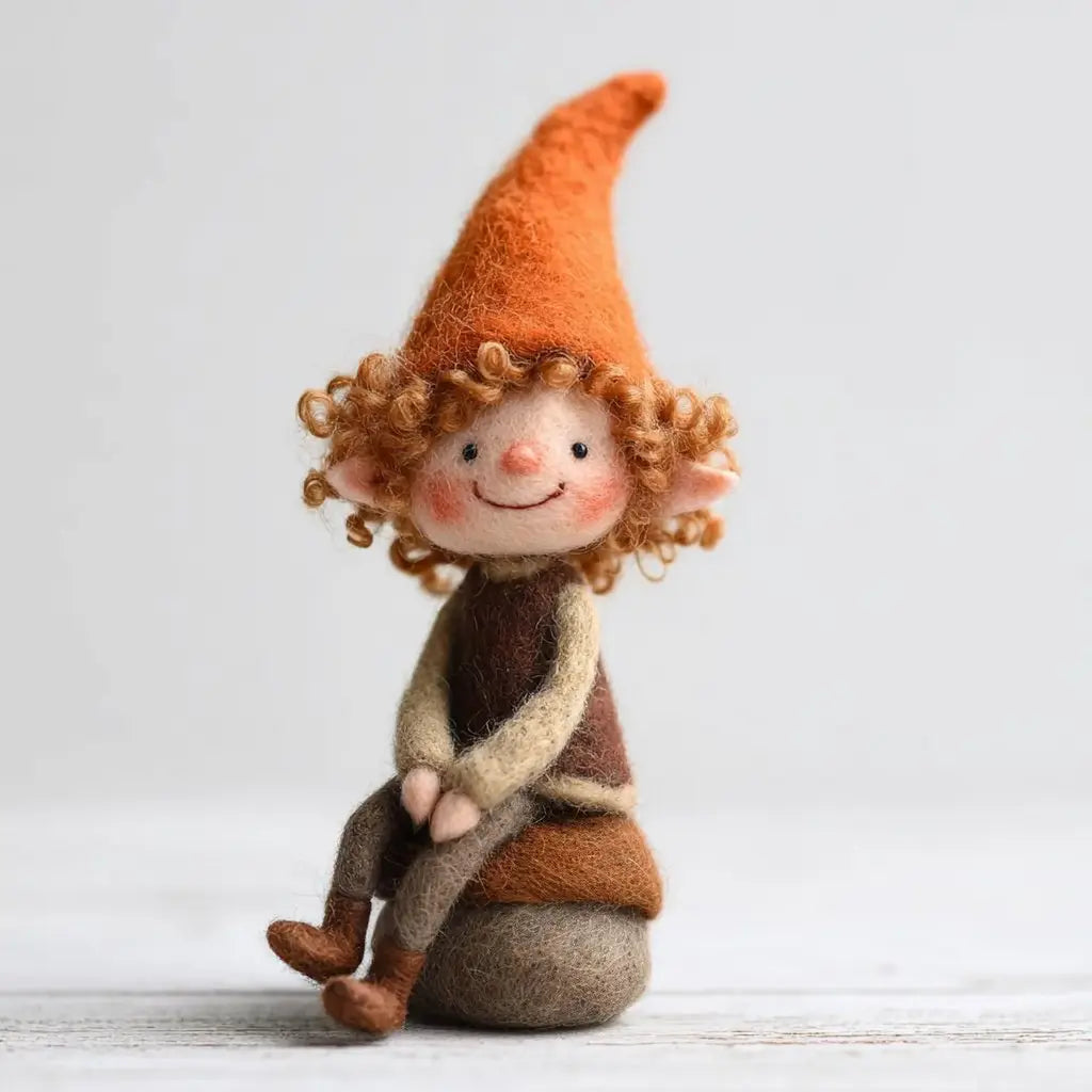 Felted gnome figurine with an orange hat and brown outfit on a light background