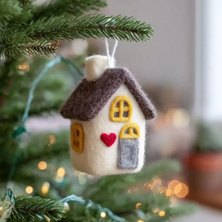 Felt house ornament with a red heart on a Christmas tree
