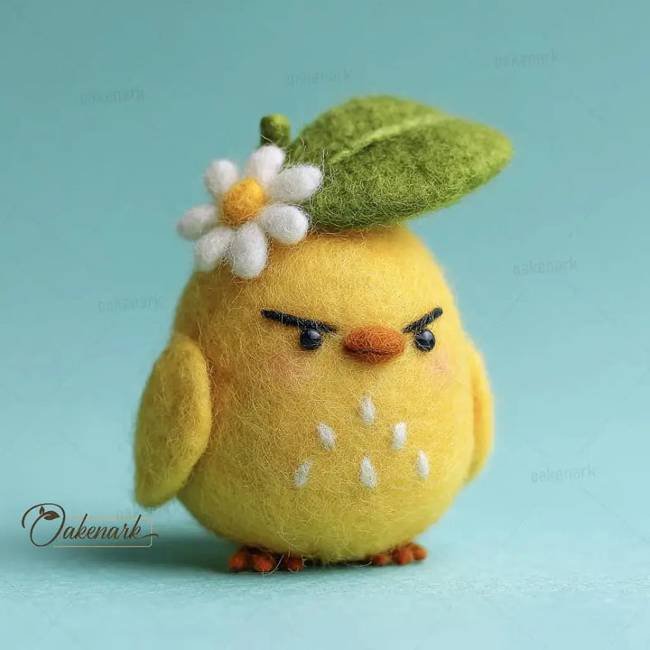 Yellow felt chick with a flower and leaf on a light blue background