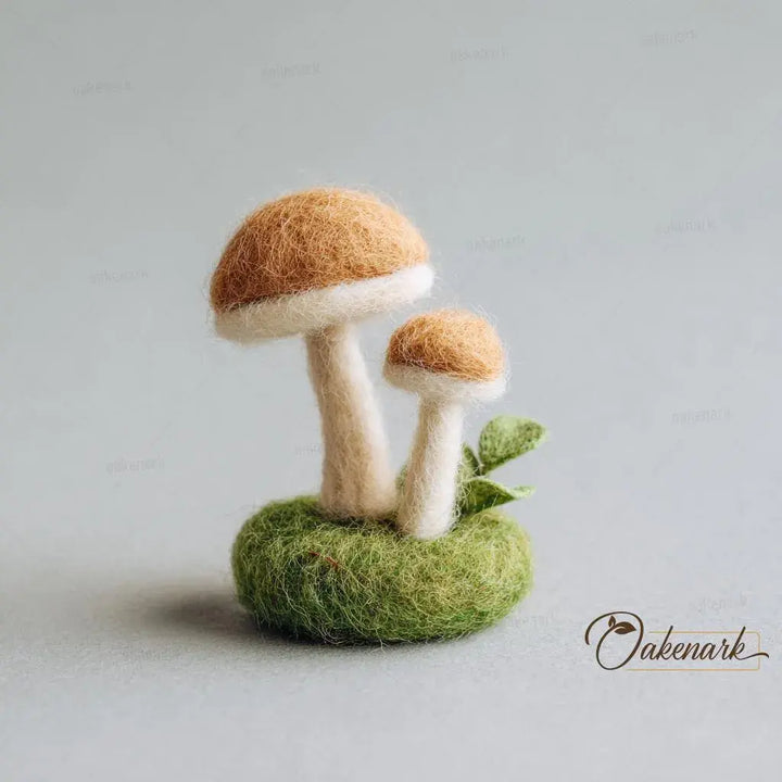 Felted mushroom sculpture on a green base with a plain background
