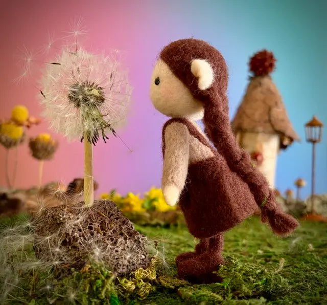 Stuffed monkey toy with dandelion in a whimsical outdoor setting
