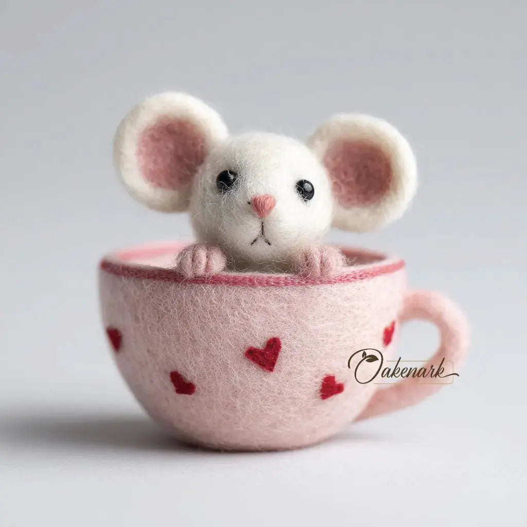White mouse plush toy inside a pink teacup with heart patterns on a light gray background.