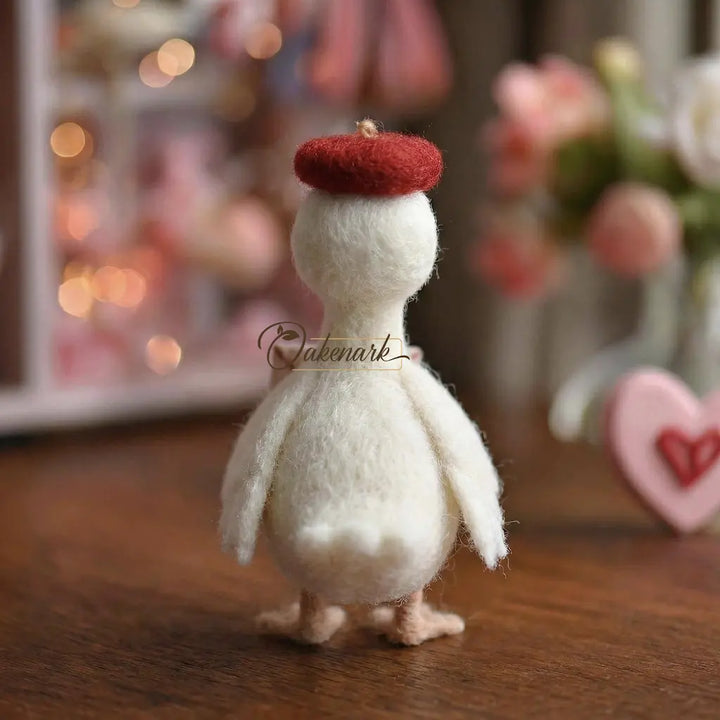 Small white figurine with a red hat on a wooden surface, blurred lights and flowers in the background.