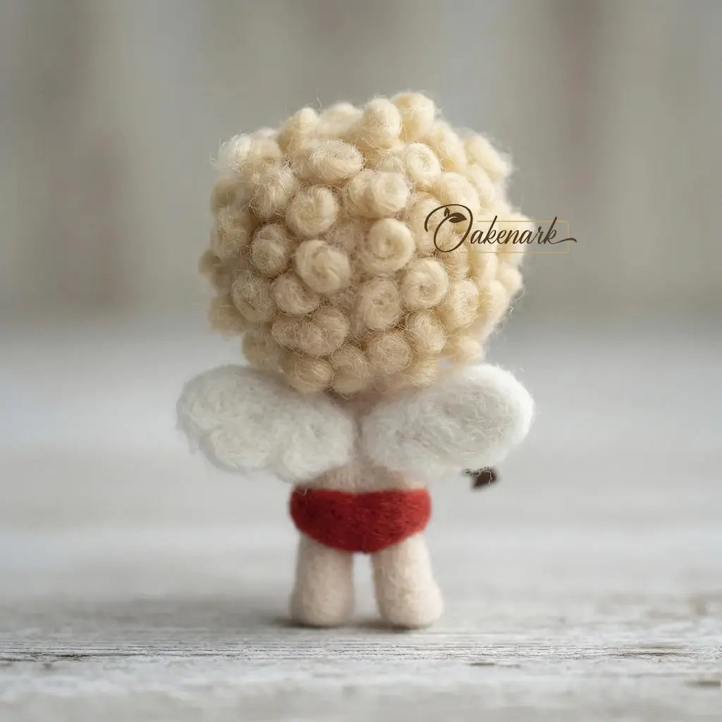 Small plush toy with a fluffy beige head and white body, wearing a red outfit on a wooden surface.