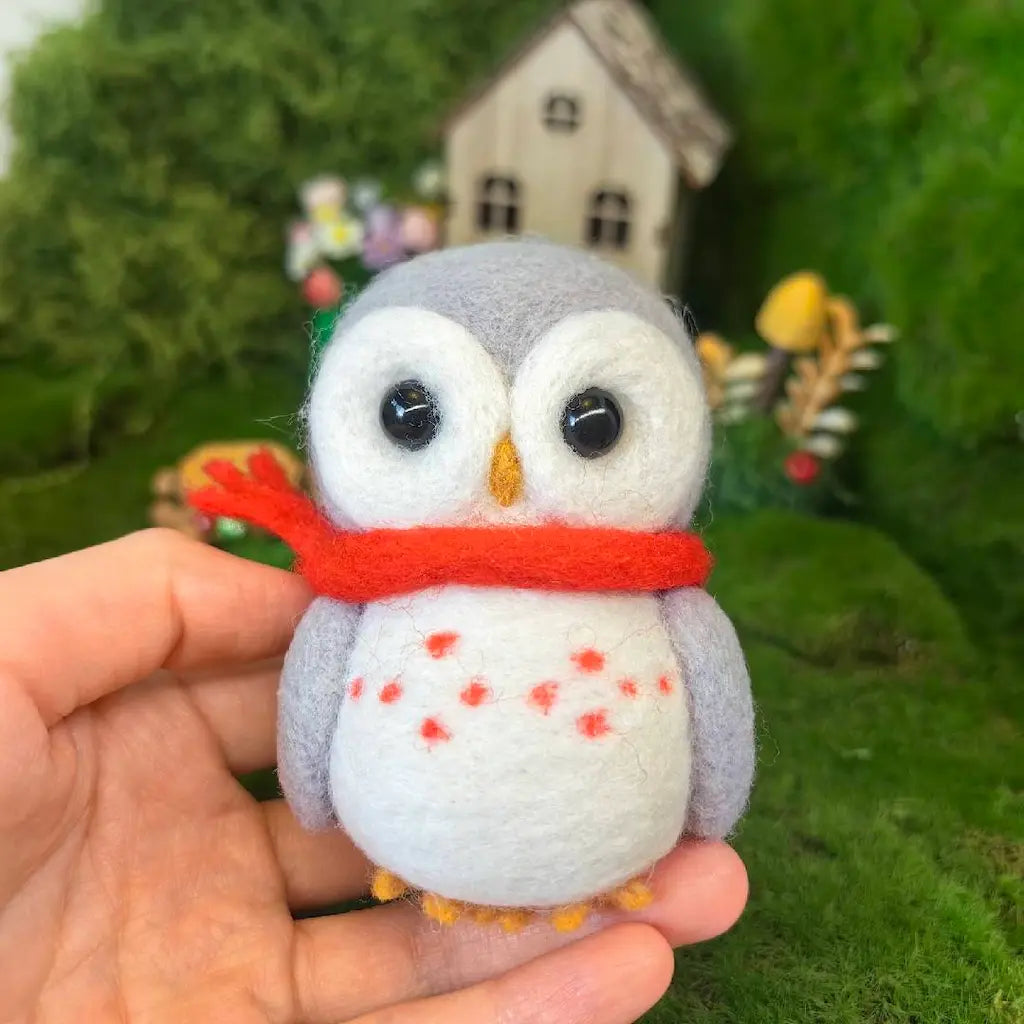 A small felt owl toy being held in a person&