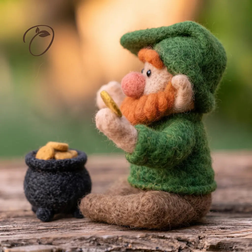 Side view of a felt leprechaun with an orange beard, pink nose, raised coin and crossed brown boots beside a black pot.