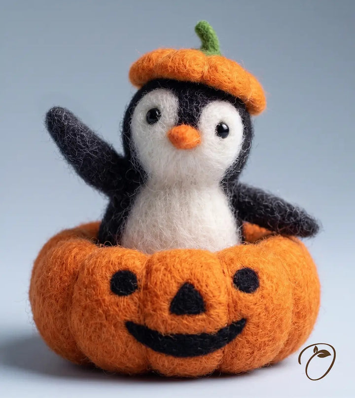 A cute felt penguin toy wearing an orange pumpkin hat, sitting inside an orange jack-o&