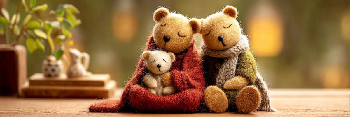 Handmade needle-felted bear family figurines cuddling together under cozy wool blankets in a warm home setting.
