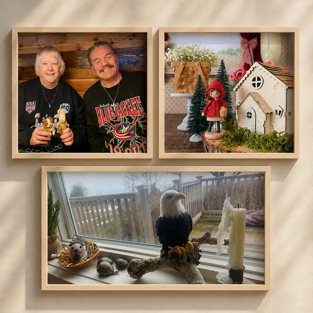 Three framed pictures on a wall, featuring people, a miniature scene with a house and trees, and a window view with a bird and candles.
