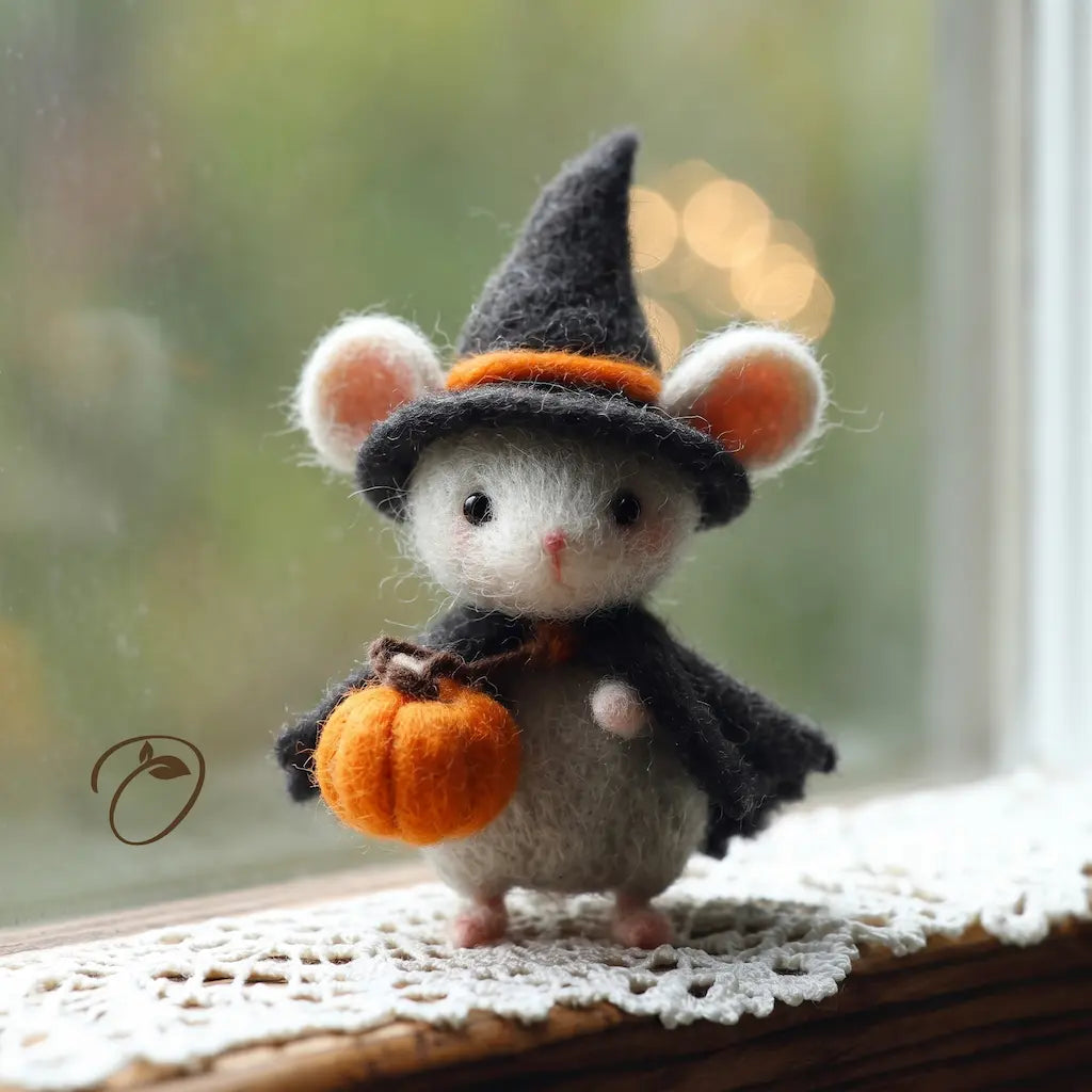 Handmade wool felt witch mouse figurine holding an orange pumpkin