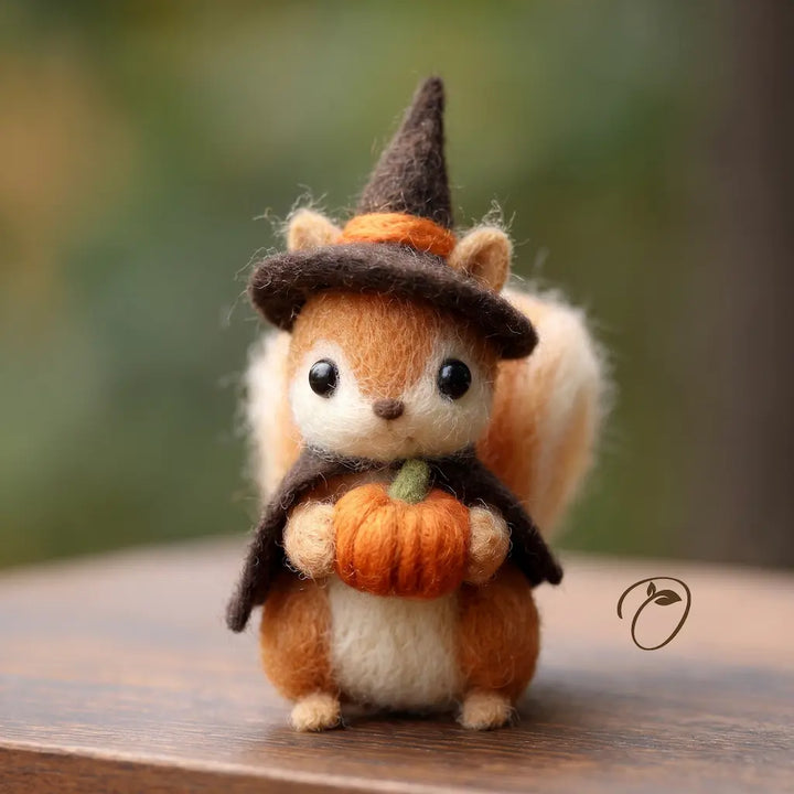 Handmade wool felt witch squirrel holding an orange pumpkin