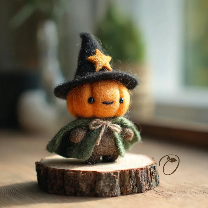 Side view of a felt pumpkin witch figurine with pointed hat and flowing cape