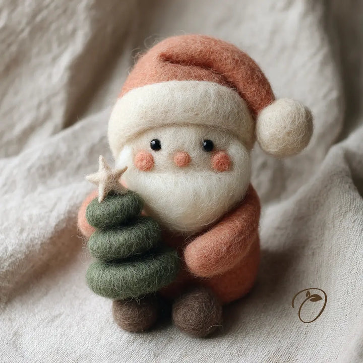 A handcrafted felted wool Santa Claus figurine holding a small green felted Christmas tree with a star topper, set against a soft beige fabric background.