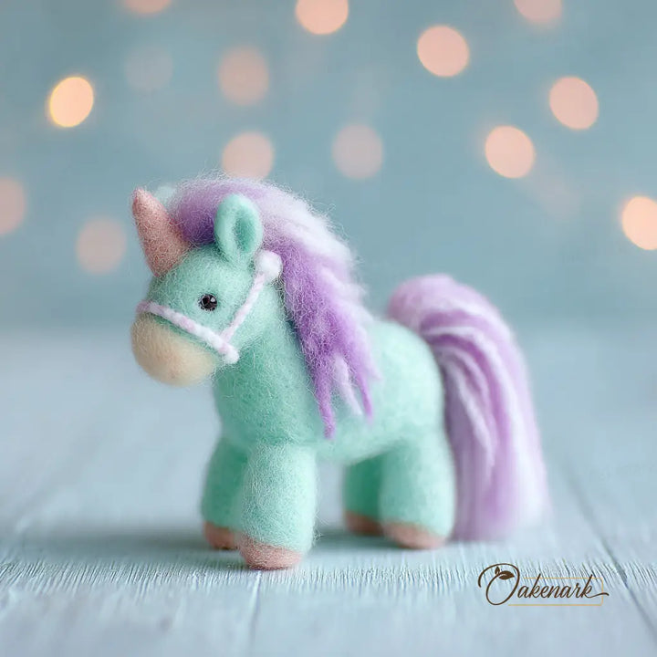 Felted unicorn toy with a purple mane and tail on a light blue background