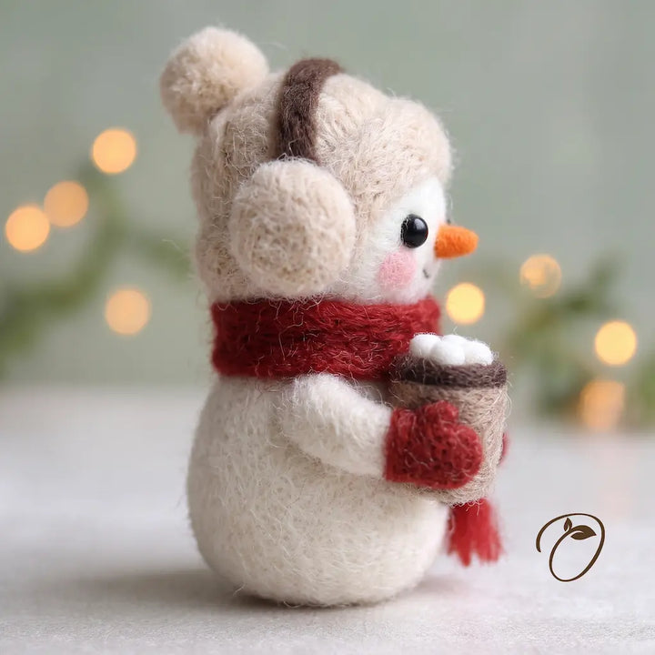 Side view of Cocoa Snowman felt figurine showing its cream pom-pom hat, earmuff, red mitten and miniature cocoa cup
