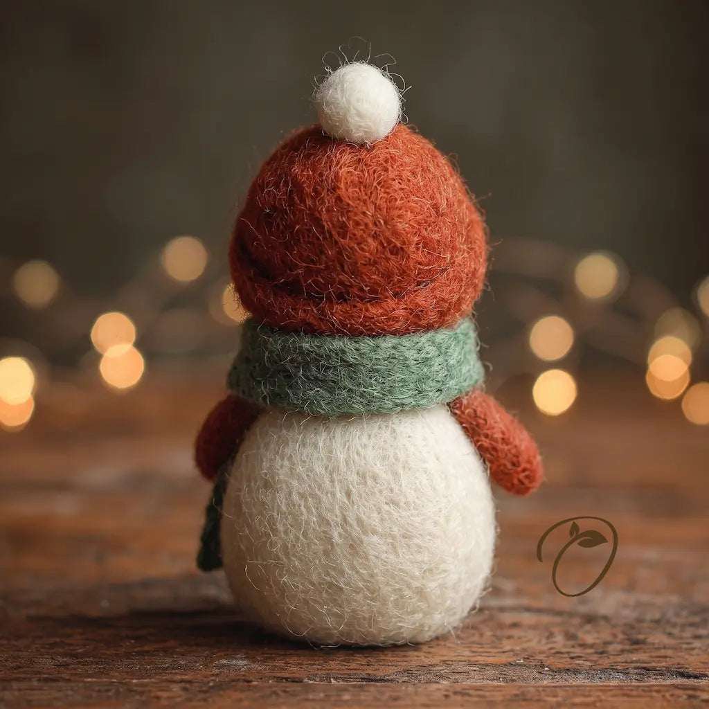 Back view of Hearthside Snowman wool felt figurine showing its rust-red hat, white pom-pom and sage-green scarf