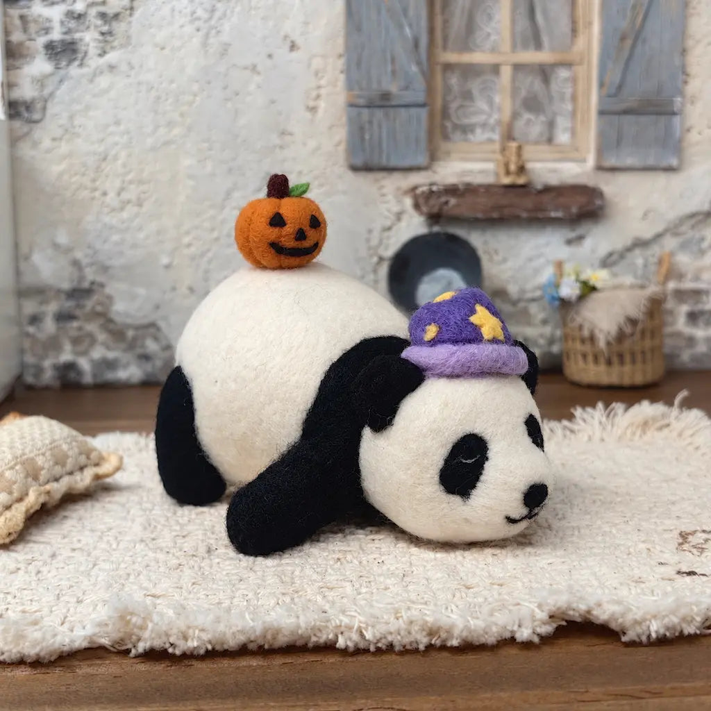 Handmade Sleepy Panda with Pumpkin wool felt figurine resting on a cream rug, wearing a purple star-patterned nightcap with a smiling orange jack-o&