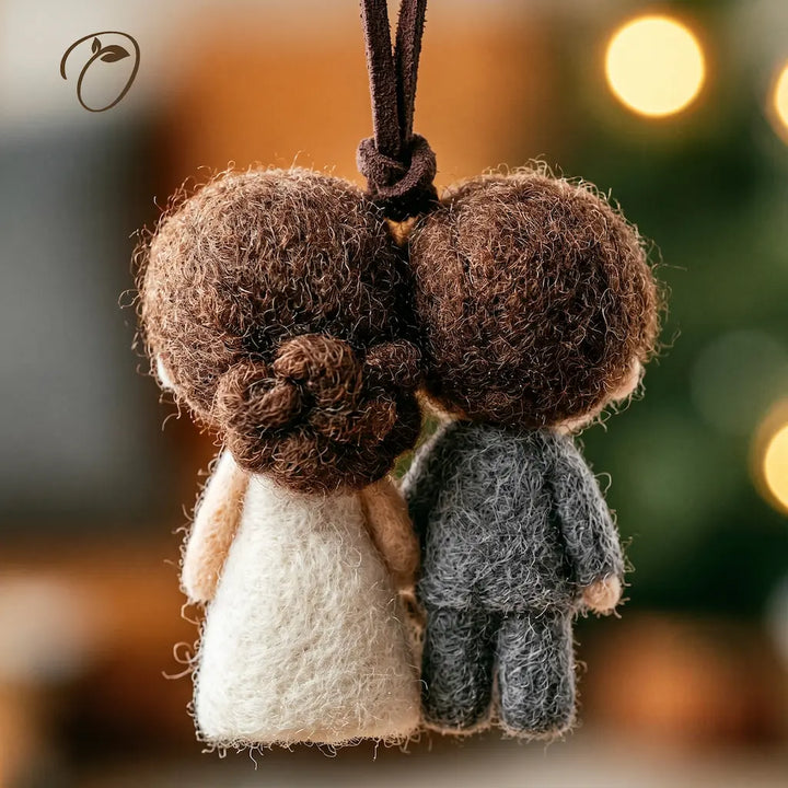 Two felt baby angel ornaments shown from behind, hanging side by side. One has brown hair and a cream dress, and the other has brown hair and a dark gray outfit.