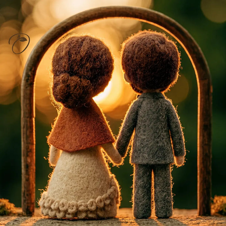 Two felt doll figures seen from behind, holding hands under a wooden arch with a warm glowing sunset background.